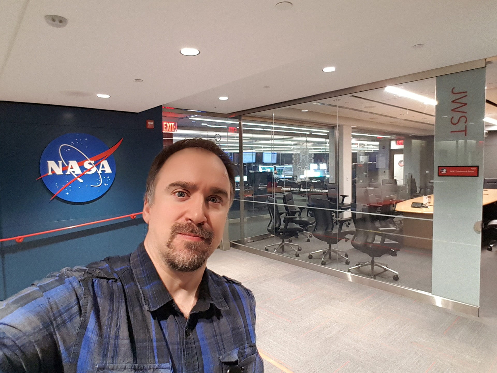 Örs Hunor Detre, Organisator des Student Spacelab Network SSN, in einem Büro mit NASA-Logo im Hintergrund